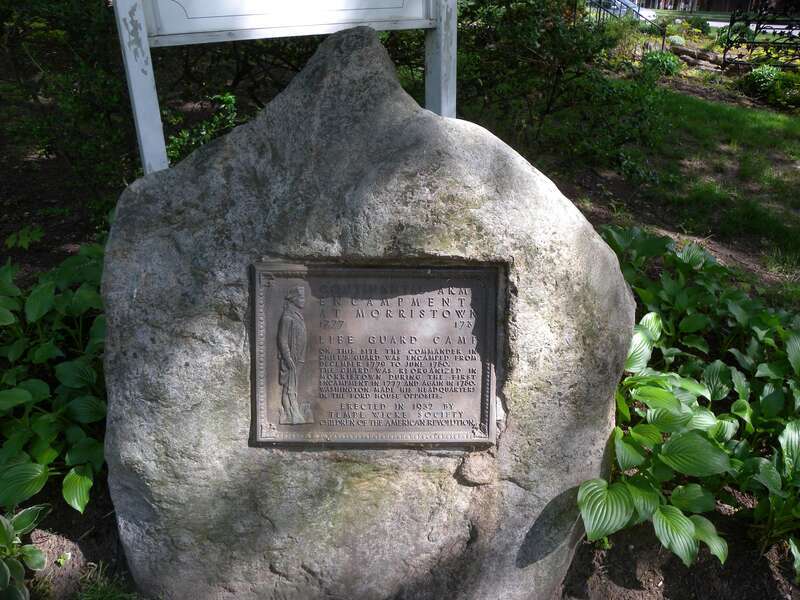Looking south from Morris Avenue at plaque locating the camp of General Washington's 1780 bodyguard detail, on a mostly sunny afternoon.