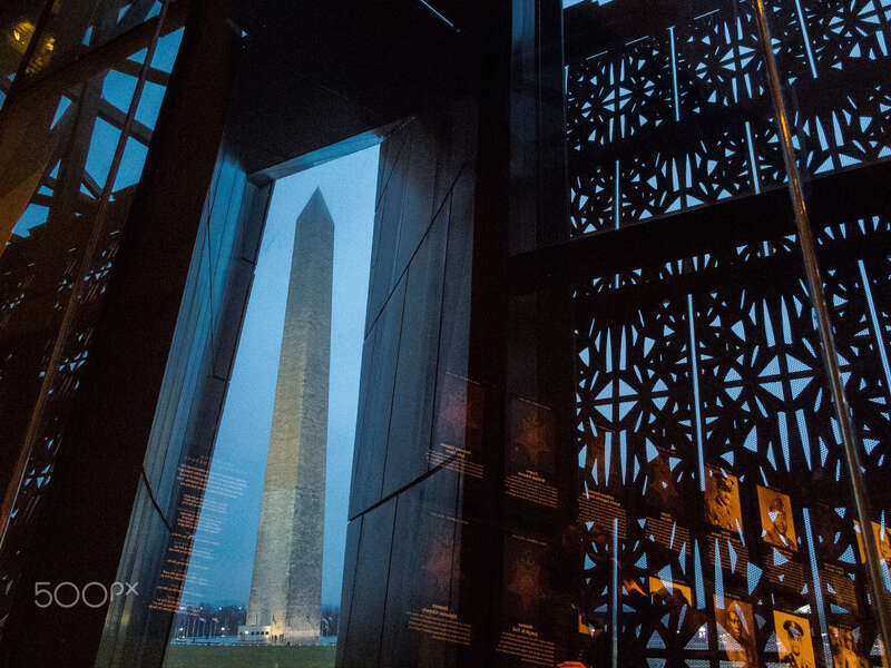 500px provided description: The Washington Monument framed through the architecture of the NMAAHAC [#g12 ,#Canon ,#Washington ,#Museum ,#Culture ,#DC ,#January ,#Mall ,#Jason knauer ,#NMAAHAC]