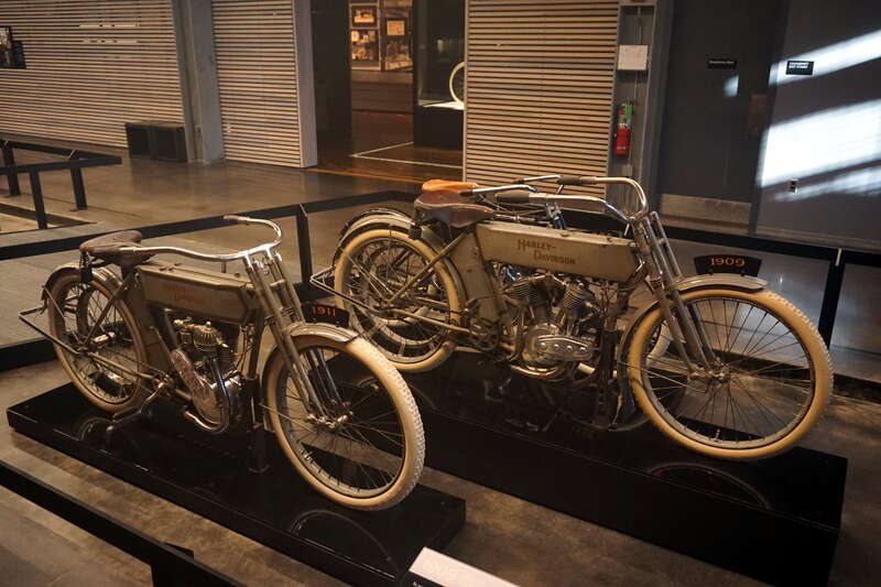 A 1911 Harley-Davidson Model 7-A (with an Atmospheric-Valve Single engine) and a 1909 Harley-Davidson Model 5-D (with an Atmospheric-Valve V-Twin engine) at the Harley-Davidson Museum in Milwaukee, Wisconsin (United States).