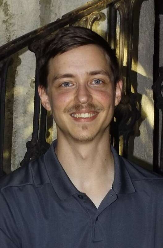 Timothy Holdiness posing on a castiorn spiral staircase on Historic Front Street in Natchitoches, Louisiana.
