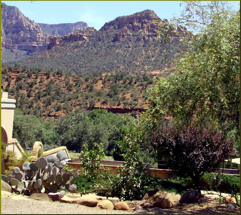 (1 in a multiple pictures set)
Looking between to ofo the stores on the main street of Sedona, AZ, you get a view of the scenery that surronds the town.  Note the cactus in the foreground.