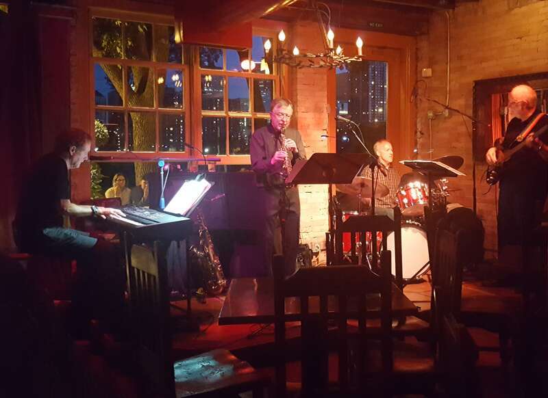 The Larry McDonough Quartet performs at the Aster Cafe in Minneapolis, Minnesota on July 1, 2018, featuring Richard Terrill on sax (center) and Larry McDonough on piano (far left).