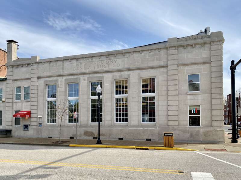 Built in 1921, this Classical Revival-style building was constructed to house the New Harmony Bank and Trust Company.  The building is clad in limestone with two symmetrical street-facing facades, one-over-one windows, a bracketed cornice, rusticated