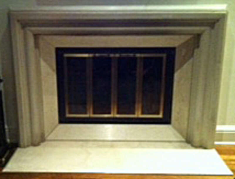 A picture of a fireplace with stone and marble mantle and glass grating.