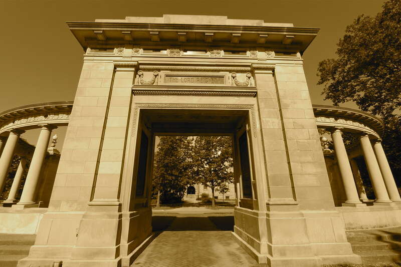 Oberlin OH.  The annual Oberlin College commencement ceremony begins with a march below Memorial Arch.  Sepia-tone image.