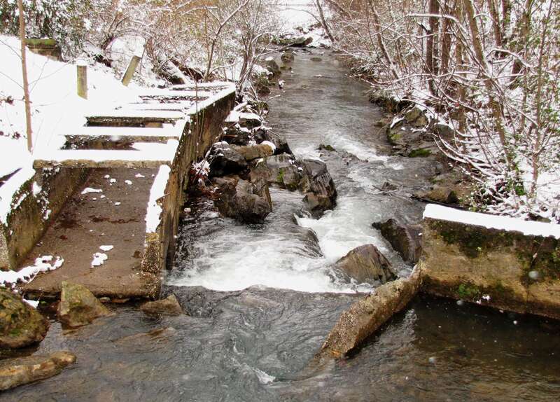 The snow-covered remains of the Pistol Creek Mill, namely the millrace (left) and part of the mill dam (right), at Greenbelt Park in Maryville, Tennessee, USA.  These ruins are listed on the National Register of Historic Places.