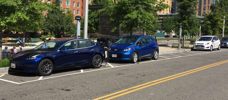 Tesla Model 3 (left) and Chevrolet Bolt EV (center) and Ford C-Max Energy (right) charging at a ChargePoint Network on street public charging station. Washington, D.C.