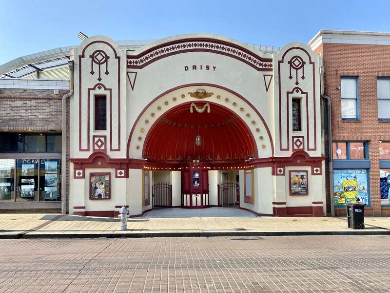 Built in 1912-1913, this Renaissance Revival-style building was constructed for Sam Zerilla to serve as a live performance and nickelodeon movie theater known as the Daisy Theatre.  The building features a stucco-clad front facade with arched gabled