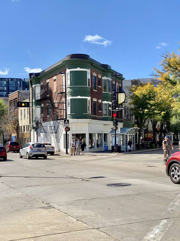 Built in 1906, this Queen Anne-style flatiron building was designed by Claude and Starck, and is known as the Kirch Building.  The building is clad in red brick with a low-slope roof enclosed by a parapet, a cylindrical two-story corner turret,