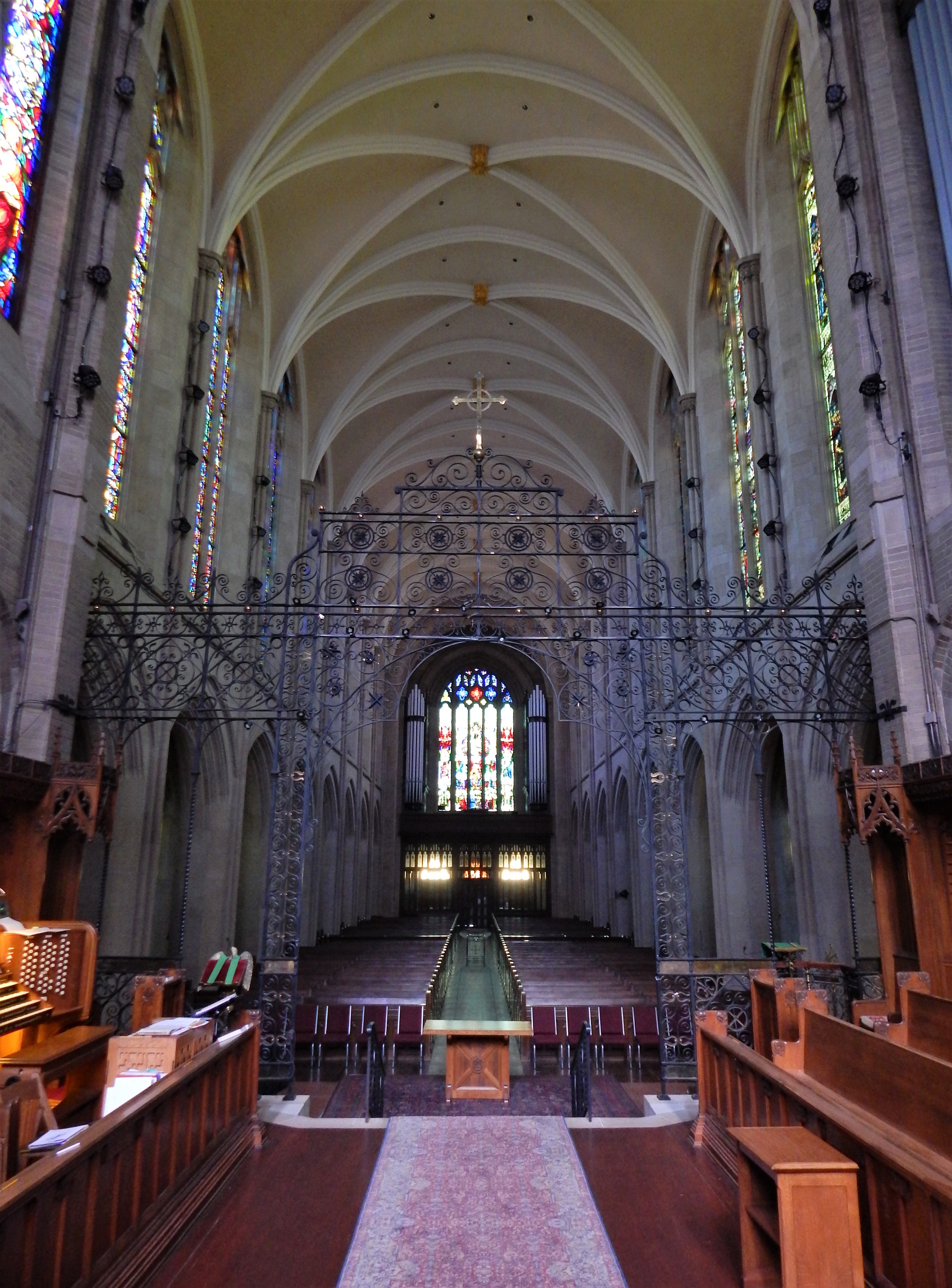A view from the raised chancel, through the rood screen into the nave, terminating with the Last Judgment Window on the north facade.