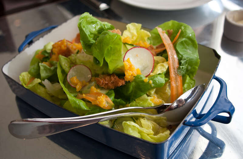 Homemade salad prepared with butter lettuce with garden baby carrots, roasted golden beets, cucumber, pickled radish, torn croutons, and citrus vinaigrette