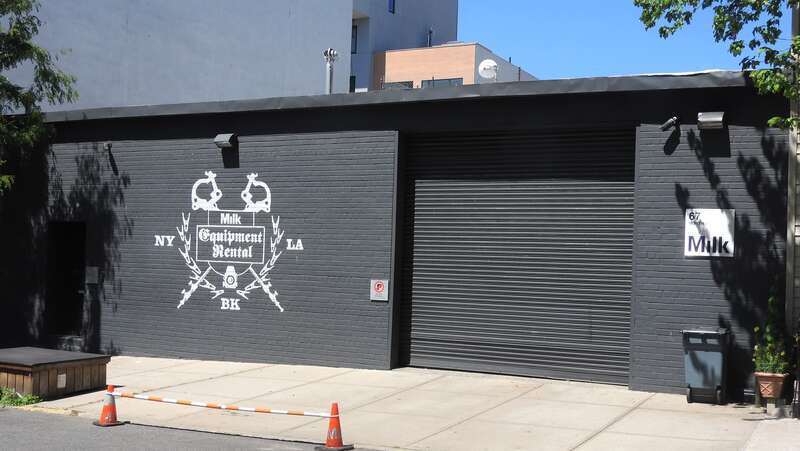 Looking north across street at shop closed for virus, on a sunny midday