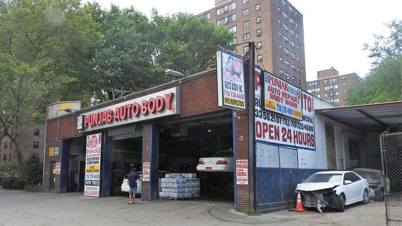 Looking west at auto body shop on a mostly clear midday.