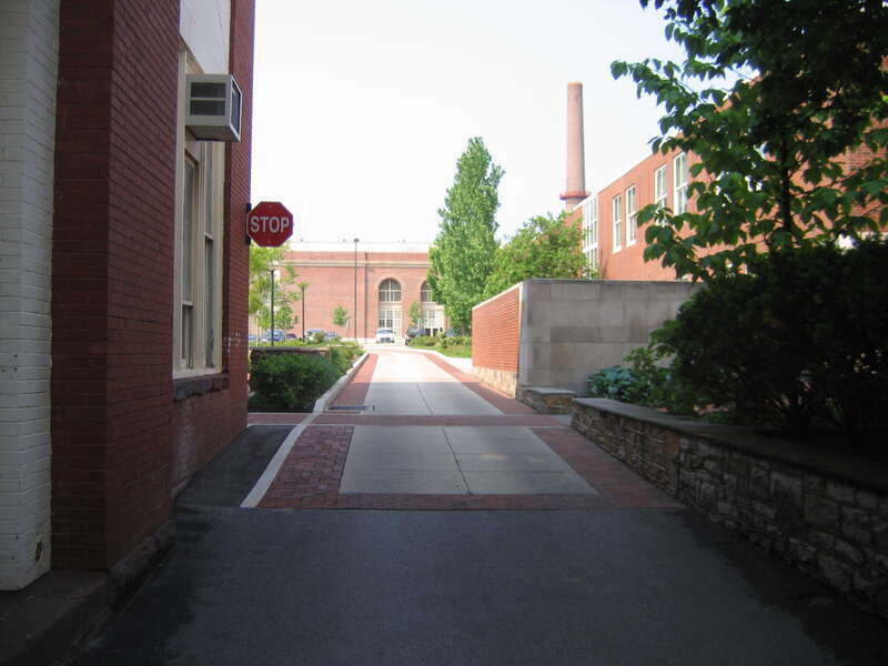 A driveway within the Engineering Parking Lots, University Park, Pennsylvania.  Note the textured pavement and the stop sign along the left side (the MUTCD stipulates that a stop sign shall be placed on the right side, with left-side signs being