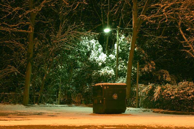 A TFC dumpster at night on Watts Street in Durham, North Carolina.