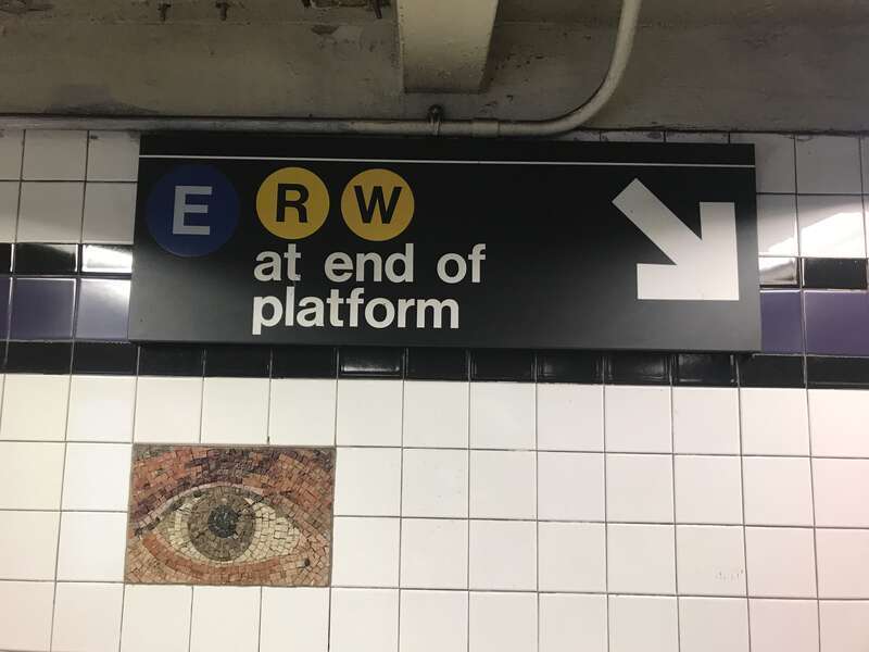 A sign at the Chambers Street IND station, pointing downward to a platform, and to the then-new transfer to the Cortlandt Street BMT station. Also visible is detail of the station-wide art installation &quot;Oculus&quot;.