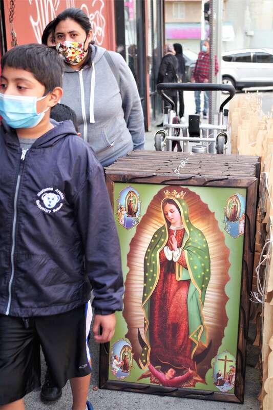 Family walks through the discount and garment district in downtown Los Angeles, properly wearing their masks!  Covid 19 Life Scene.