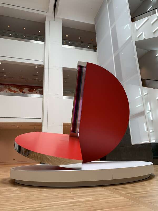 Image of a sculpture titled &quot;Folded Circle Dynamics Red Phase III&quot; by Fletcher Benton on display in the main hall of the Indianapolis Museum of Art at Newfields