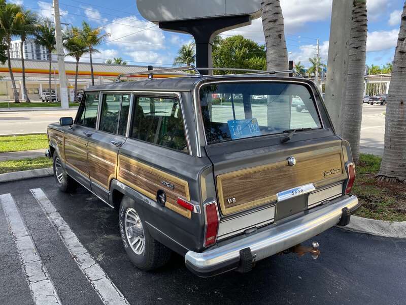 Jeep Grand Wagoneer (SJ) - the original luxury SUV - finished in gray with standard wood-grain side panels. Photographed in Coral Gables, Florida.