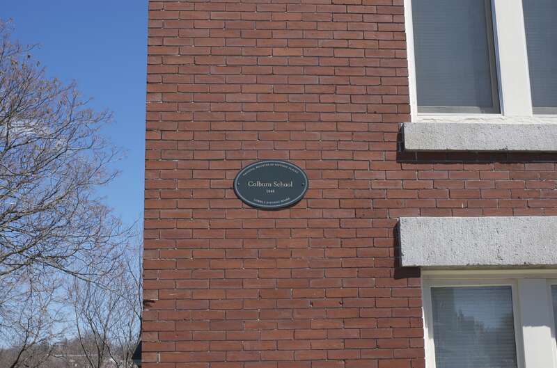Detail of the Colburn School in Lowell, Massachusetts, showing the National Register of Historic Places plaque on the front of the building.