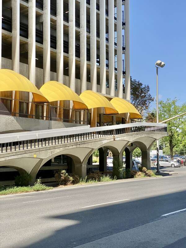 Built in 1967, this Brutalist building was designed by Warren C. Heylman to serve as a parking garage, known as Parkade Plaza.  The building features a concrete structure, exterior fins with flared brackets at the cornice, vaulted ceilings below the