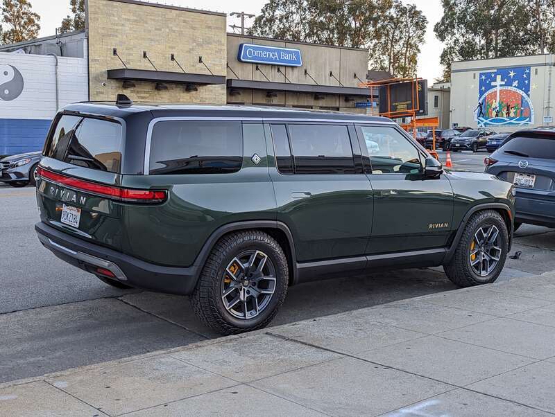Rivian R1S sport utility vehicle in a dark green color, parked on Howard Avenue in Burlingame California