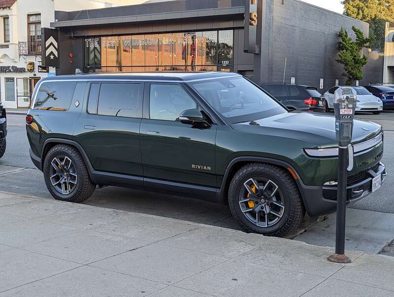 Rivian R1S sport utility vehicle in a dark green color, parked on Howard Avenue in Burlingame California