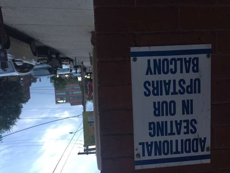 A sign posted on a building in Southern New Hampshire that reads, &quot;ADDITIONAL SEATING IN OUR UPSTAIRS BALCONY&quot;
