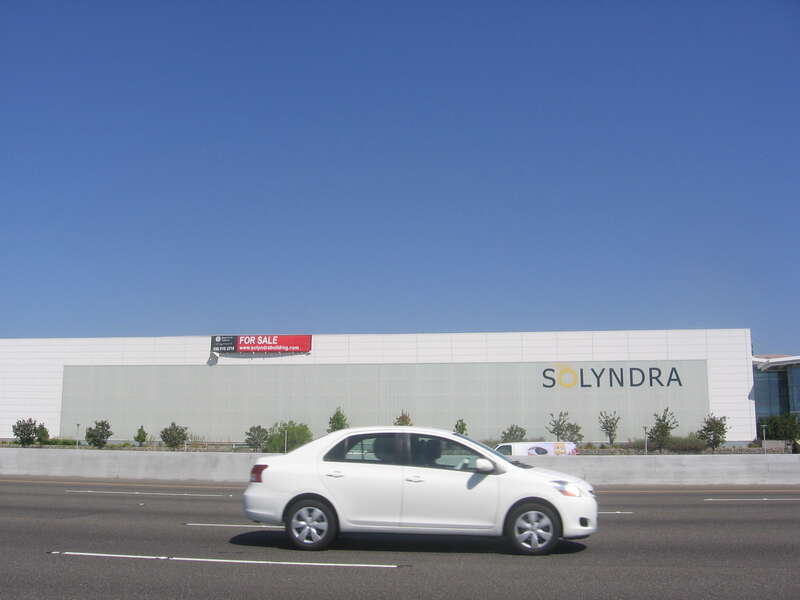 A large factory building owned by Solyndra in Fremont, California, USA with a &quot;For Sale&quot; sign on it.  View is from the shoulder of the southbound side of Interstate 880 (Nimitz Freeway).