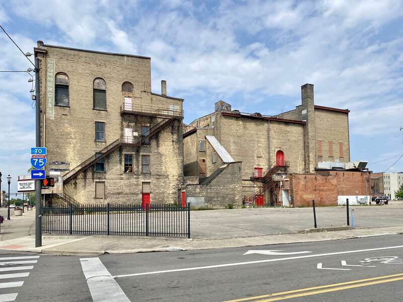 Built in 1890, this Richardsonian Romanesque Revival-style building was designed by Samuel Hannaford for Paul J. Sorg to serve as an opera house.  The building features a brick exterior with a rough-hewn stone front facade, arched window bays on the
