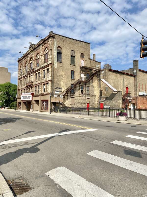 Built in 1890, this Richardsonian Romanesque Revival-style building was designed by Samuel Hannaford for Paul J. Sorg to serve as an opera house.  The building features a brick exterior with a rough-hewn stone front facade, arched window bays on the