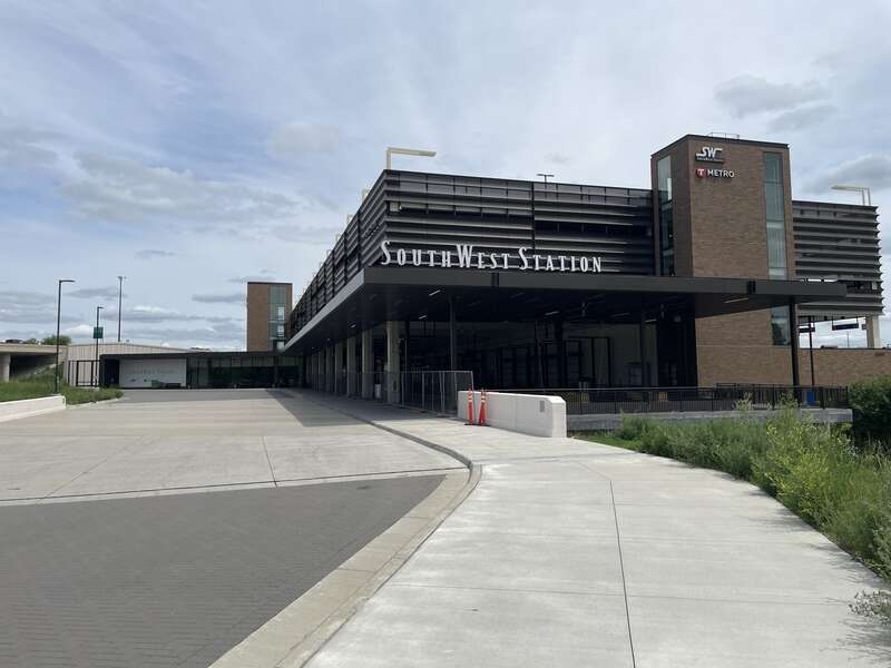 SouthWest Station in June 2024. Underneath the parking structure on the right are the platforms for the Green Line. On the left are areas for buses and an indoor bus waiting area.