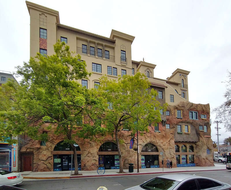 Lower floors are fake stone (plaster over metal wire,rebar, and metal stud frame)
Upper floors are stucco

Structure behind is concrete on 1F-2F, wood on 3F-7F