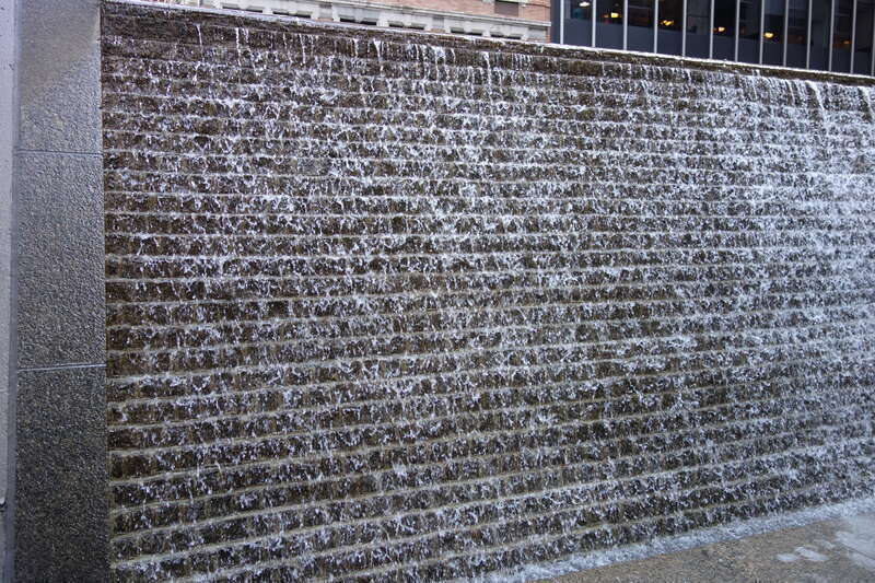 The water wall fountain at the south end 88 Pine Street Plaza, between Wall Street Plaza (88 Pine Street) and 100 Wall Street at Front Street and Pine Street in the Wall Street area of the Financial District, Manhattan.