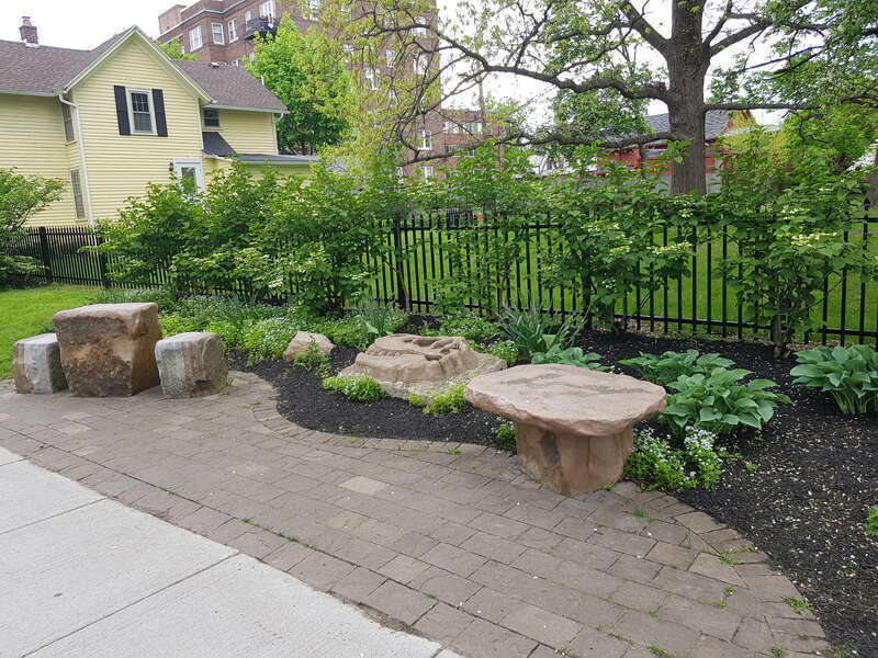 Street-side bench and chess table in the pocket park at the corner of Barrington Street and Park Avenue in Rochester, New York.
