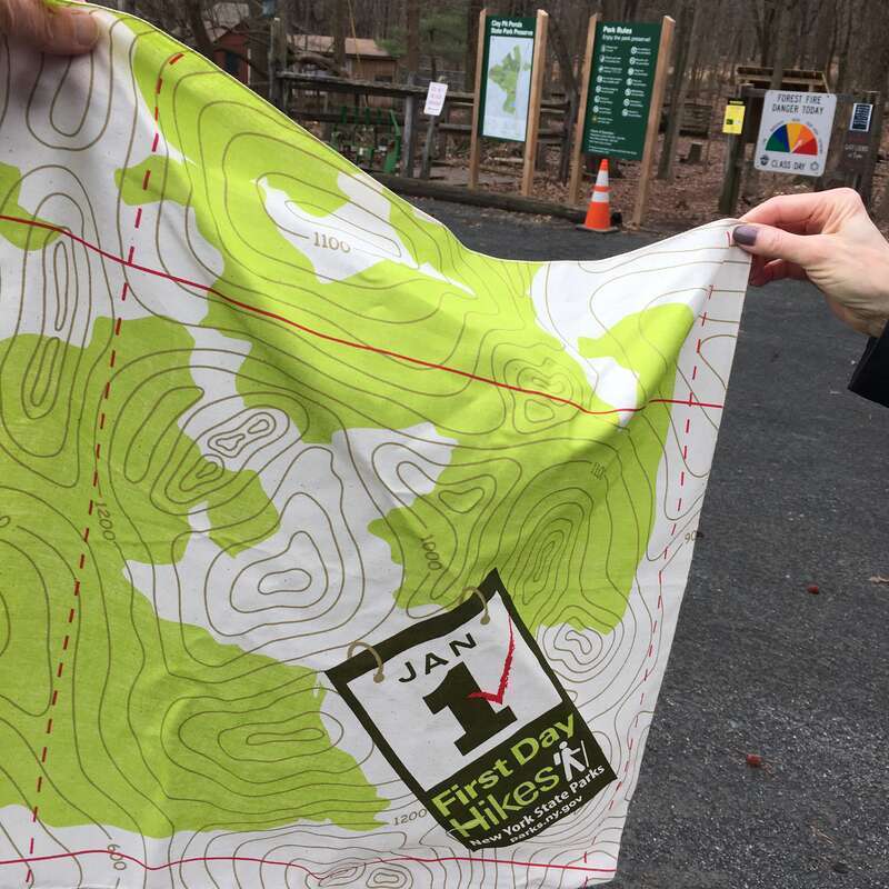 Bandana-like swag promoting New York State Parks' First Day Hikes given to participants on New Year's Day 2021 at Clay Pit Ponds State Park Preserve, Staten Island, New York.  Trail map signs for the park can be seen in the background.