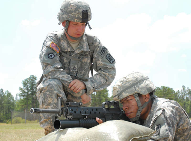 Staff Sgt. Joshua Cope, a chemical, biological, radiological, and nuclear specialist and training non-commissioned officer with the 366th Chemical Company out of Fort Stewart, Ga., assists Spc. Taylor Johnson, a CBRN specialist with the 371st