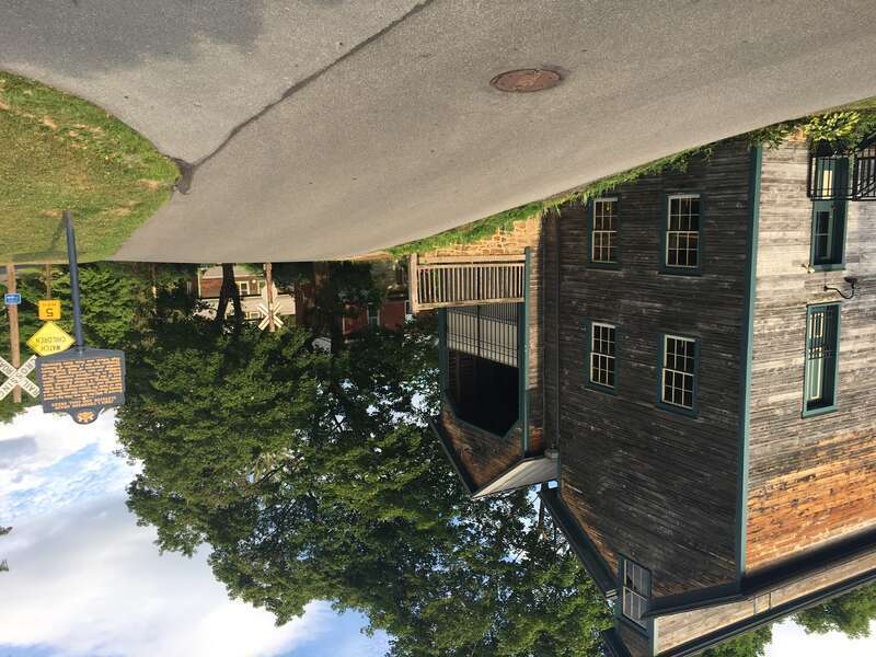 A historic building in Lemont, Pennsylvania, with a historical plaque across the street.