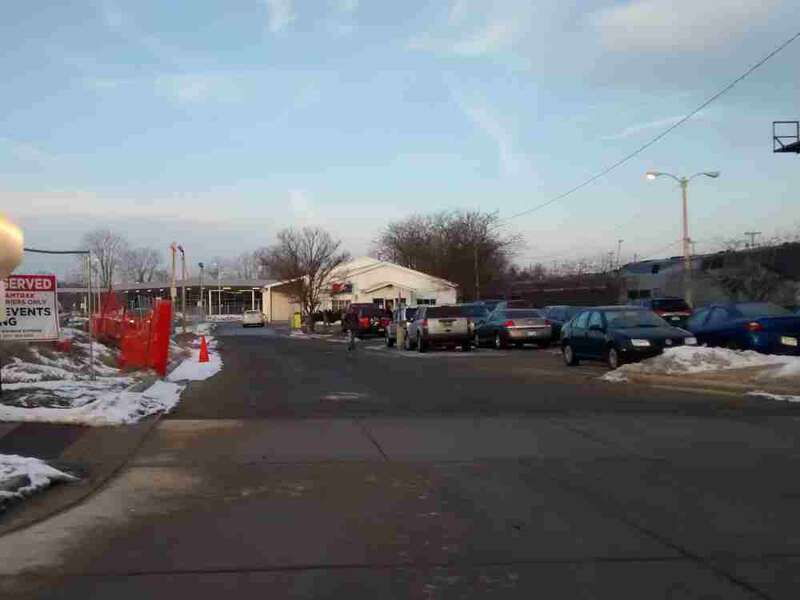 Old East Lansing Amtrak Station in front of the newly build multimodal Amtrak Station. The last train to leave the station is to the right of the station on January 25, 2016
