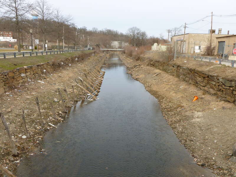 Looking west over North Canal from a bridge, located near 1 Canal Street, Lawrence, Massachusetts.  Canal Street is on the left, and Island Street is on the right.