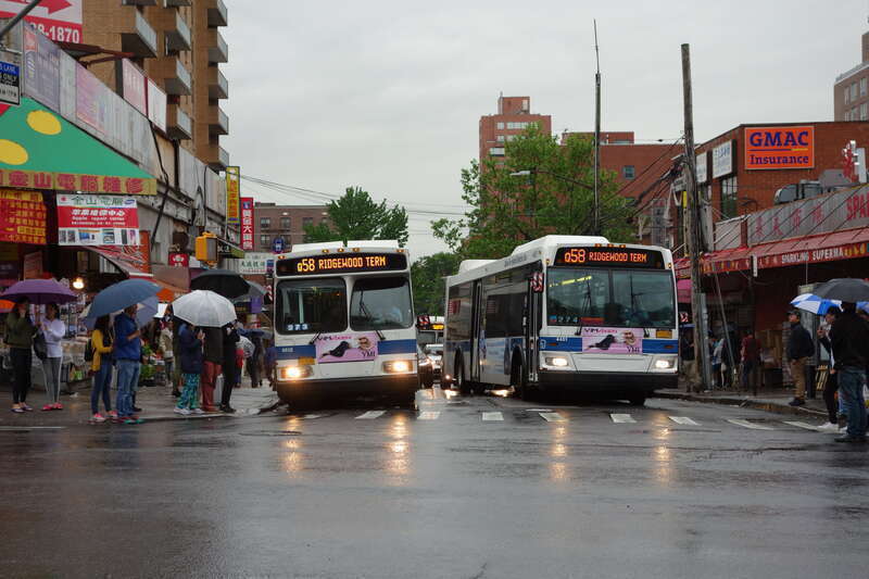 A Ridgewood Terminal-bound Q58 local bus (left) and Limited bus (right) entering service at the route's terminus at Main Street and 41st Road in Downtown Flushing, Queens.