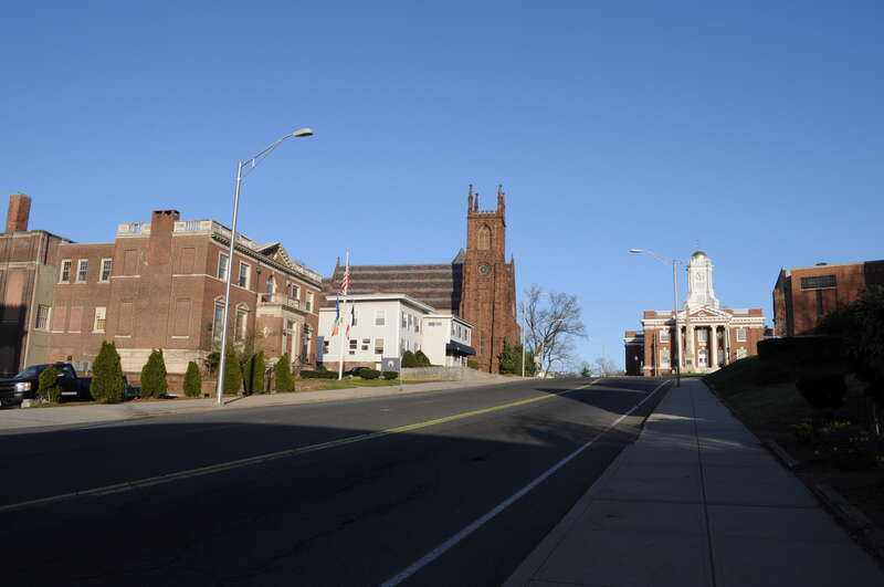 Main Street, in the center of Meriden, Connecticut, USA. From left,  Masonic Temple. Elks Lodge. Unidentified building. St. Andrew's (Episcopal). City Hall, with Soldiers Monument in front of it. Part of Temple B'nai Abraham.