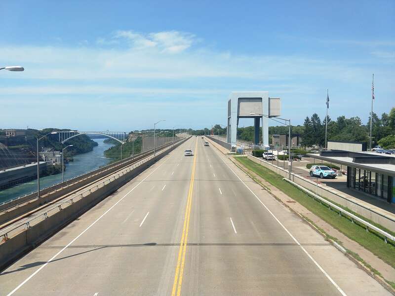 Photo of New York State Route 104 (Lewiston Road) looking north from the Niagara Power Vista at the Robert Moses Niagara Hydroelectric Power Station in Lewiston, New York. The Lewiston–Queenston Bridge and part of the Sir Adam Beck Hydroelectric