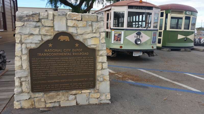 A plaque for California Registered Historical Landmark No. 1023 as well as some modified trolley cars