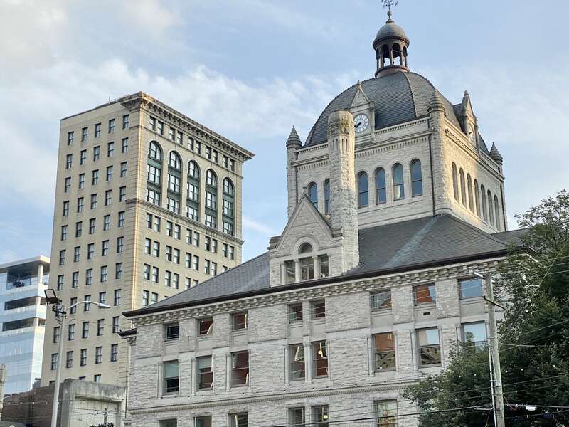 On the left, built in 1898-1900, this Richardsonian Romanesque Revival-style building was designed by Lehman and Schmitt to serve as the Fayette County Courthouse, and is the fifth courthouse to serve Fayette County, replacing a previous courthouse,