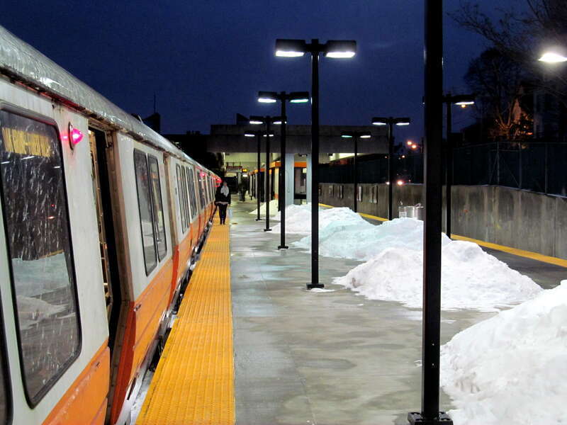An Orange Line train at Oak Grove station in a January evening