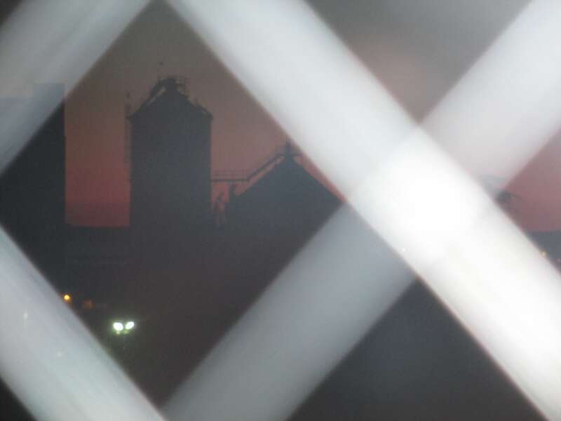 Old pulp silos that used to be part of Georgia Pacific taken through the back door at Rumor's Cabaret.  My flash reflected from crosshatch in glass so I thought picture would be no good, but it's not bad.  Saturday, before the parade, was the best
