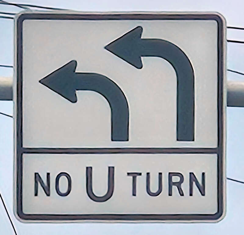 Road sign indicating that the two left lanes must turn left and no U-turns are allowed at the intersection.