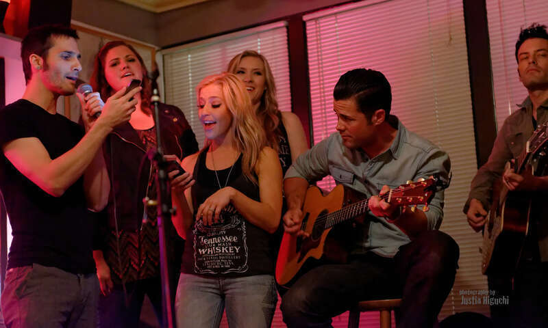 &quot;NAMM Week: Songwriter Series&quot; Songwriters Round at The Ugly Mug Cafe in Orange CA on January 22nd, 2014. Kaela Kinney (tall blonde), Ry Bradley (right), Ryan Terrigno (left), Katelyn Marie (Jack Daniels tshirt), Heidi Howard (dark hair), and Scott