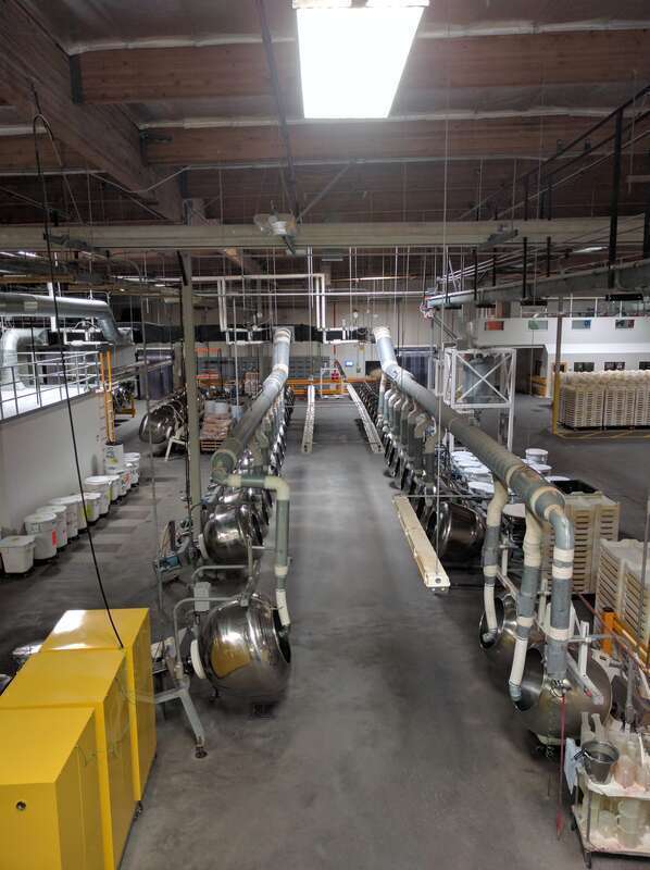 A row of machines at the Jelly Belly factory used to tumble the jelly beans to apply coatings.